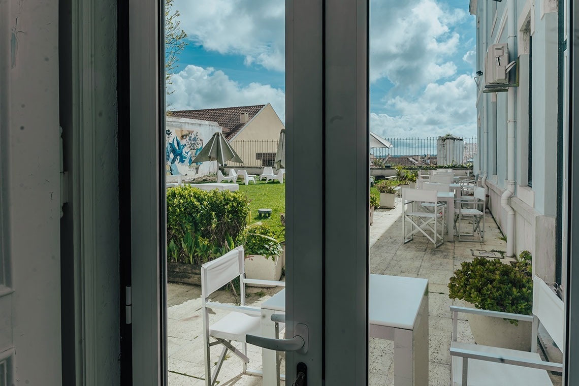 a view of a patio with tables and chairs through a glass door