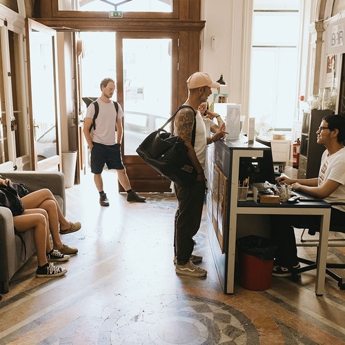 a man sits at a desk in front of a sign that says ' a ' on it