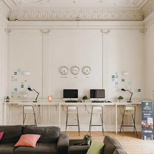 a room with three clocks on the wall and a couch