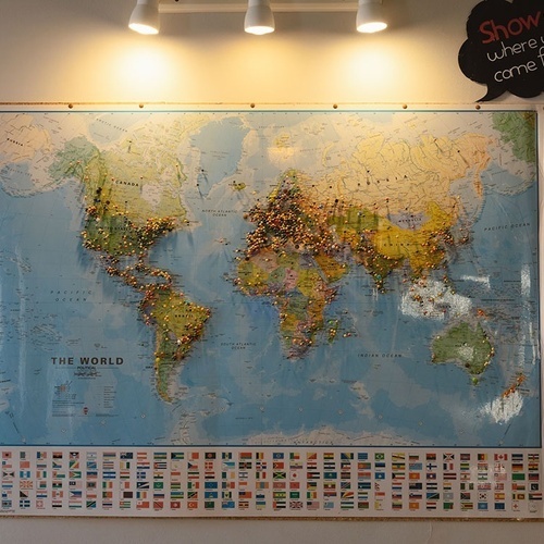 a map of the world with flags pinned to it