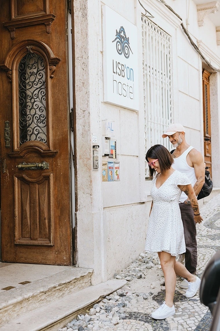 un hombre ayuda a una mujer a entrar en un hostal de lisboa