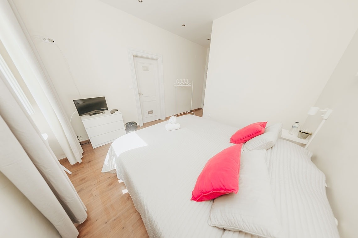a bedroom with a white bed and pink pillows