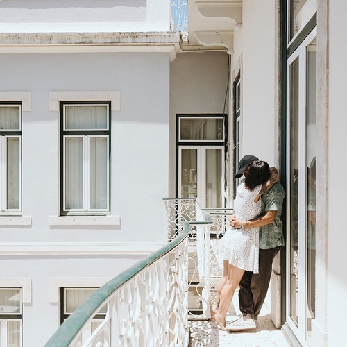 a man and a woman are hugging on a balcony
