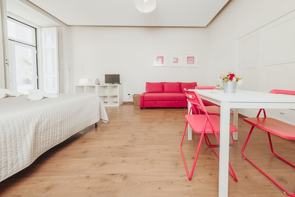 uma sala de estar com uma mesa e cadeiras vermelhas