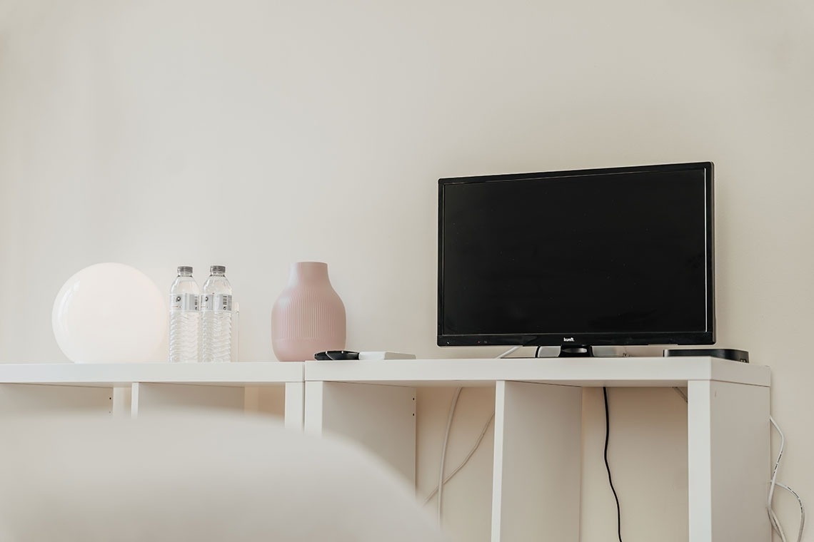 a black lg monitor sits on a white desk