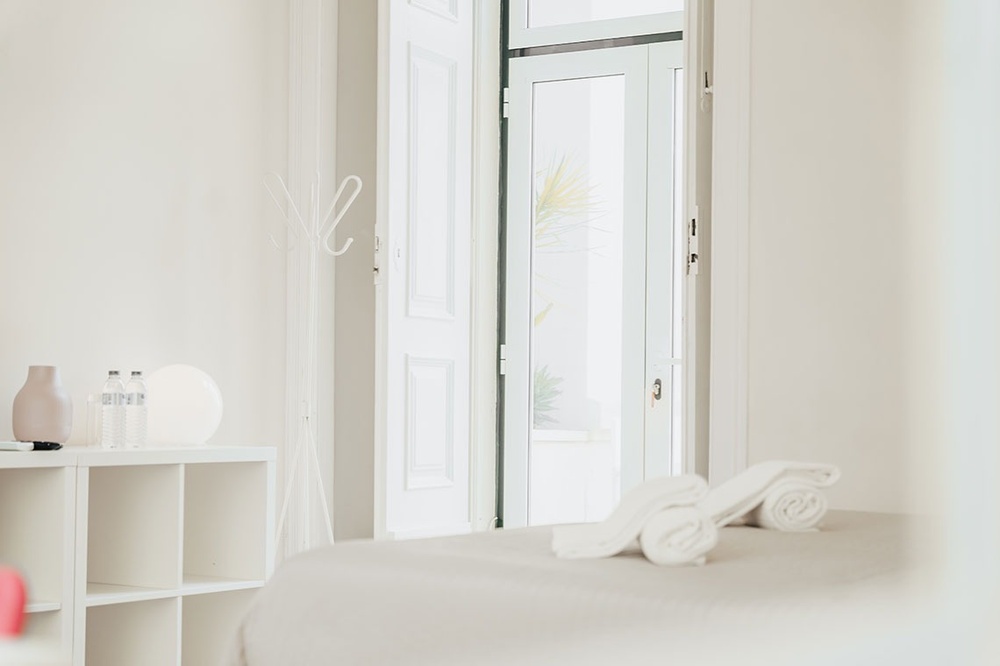 um quarto branco com toalhas e garrafas de água