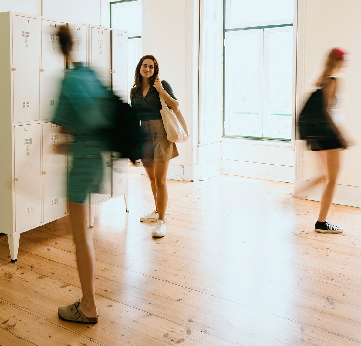 a woman standing in front of a row of lockers with the letter t on them