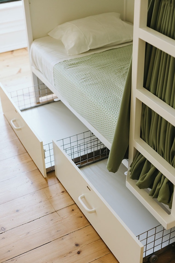 uma cama branca com um cobertor verde embaixo