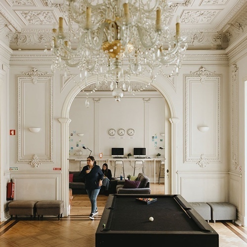 a woman walking in a room with a pool table
