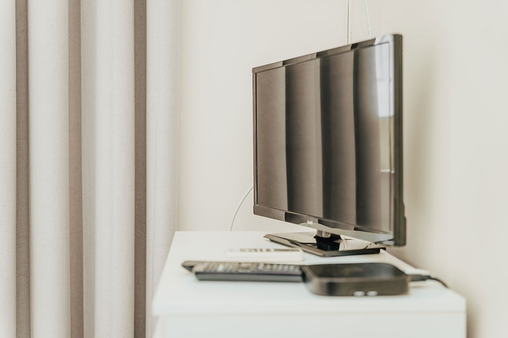 uma tv lg está sobre uma mesa branca ao lado de um controle remoto