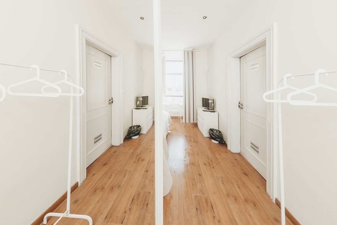 a hallway with wooden floors and white doors
