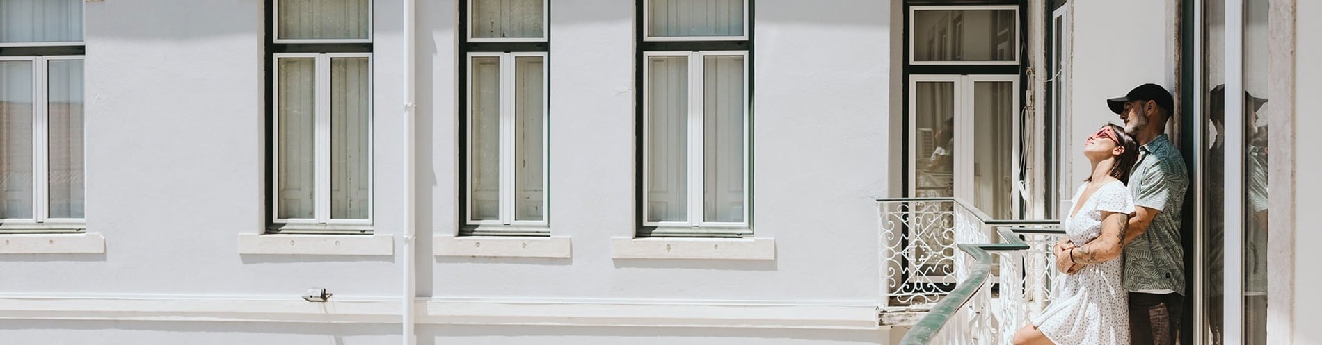 um homem e uma mulher estão em uma varanda com muitas janelas