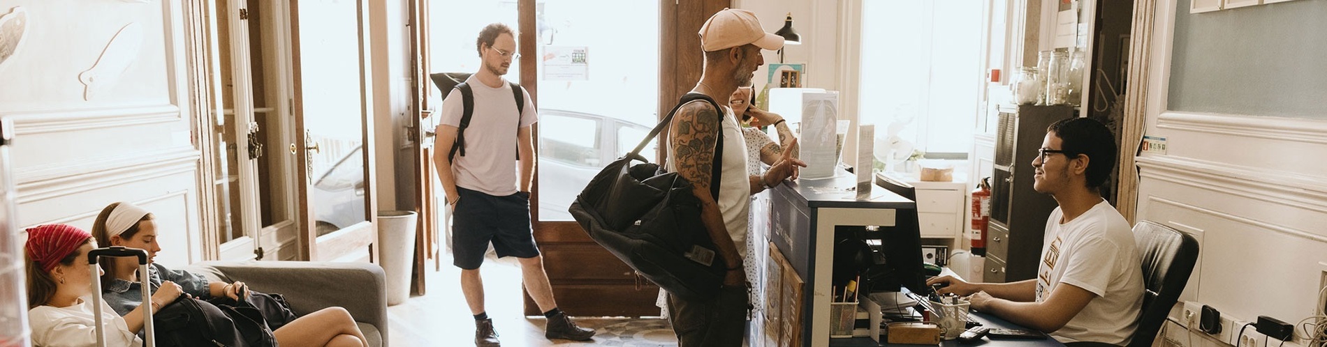 un hombre con un tatuaje en la espalda se encuentra en la recepción de un hotel