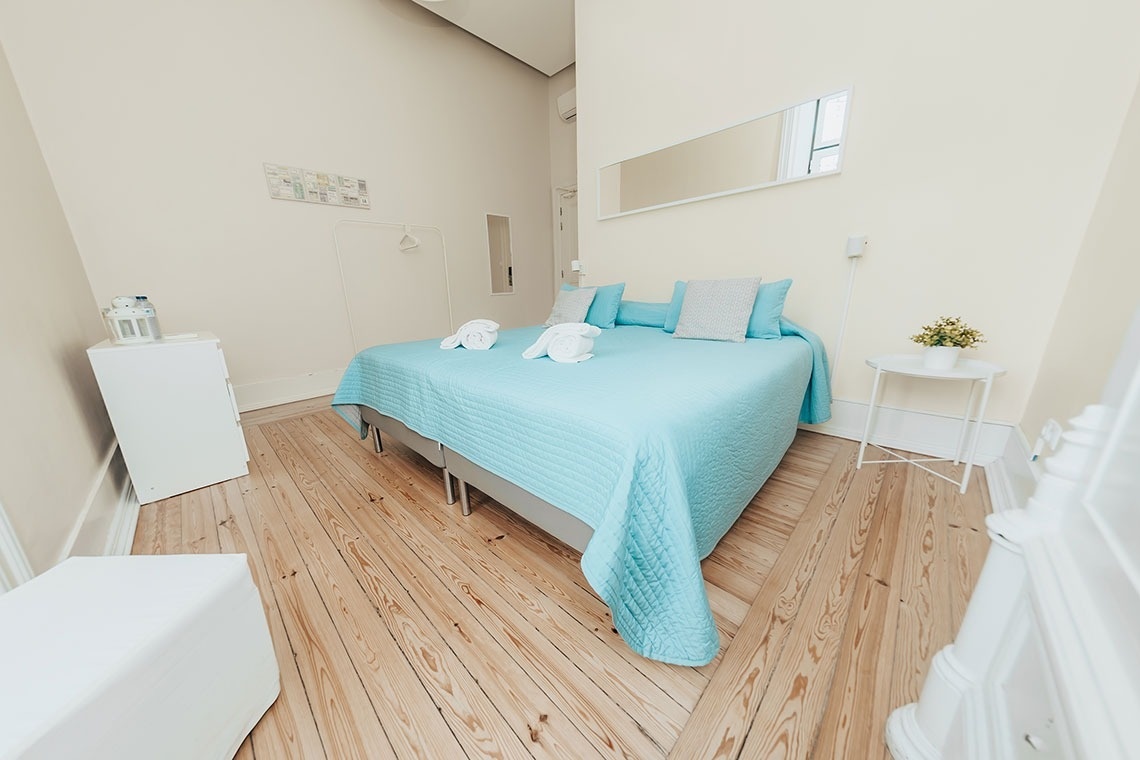 a bedroom with a bed and two white ottomans