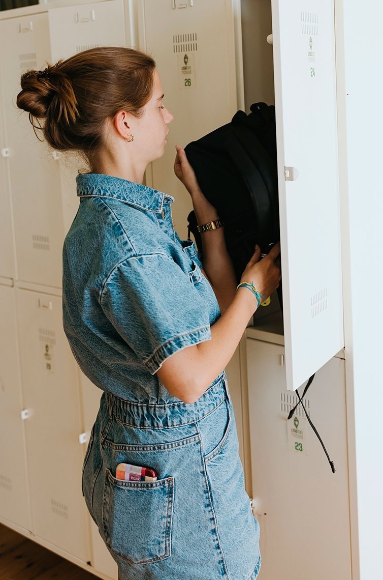 a woman reaches into a locker with the number 25 on it