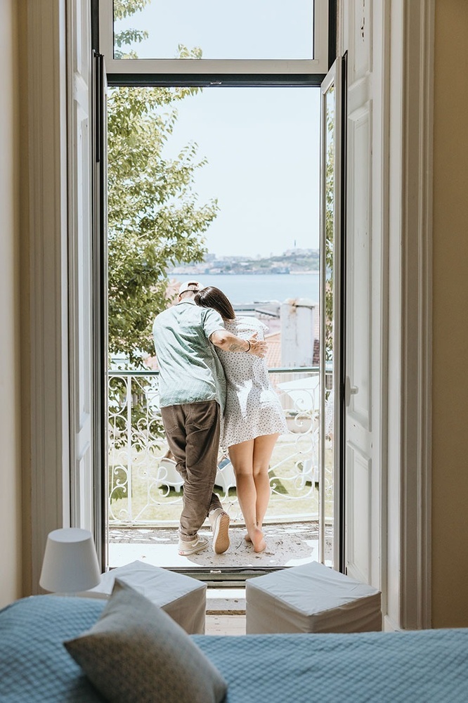 um homem e uma mulher estão em uma varanda com vista para o oceano