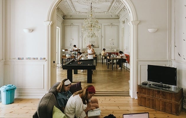 duas mulheres estão sentadas no chão em uma sala com uma mesa de bilhar