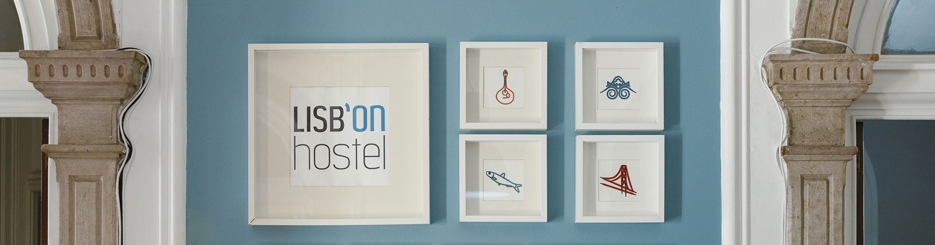 framed pictures on a wall that say lisbon hostel