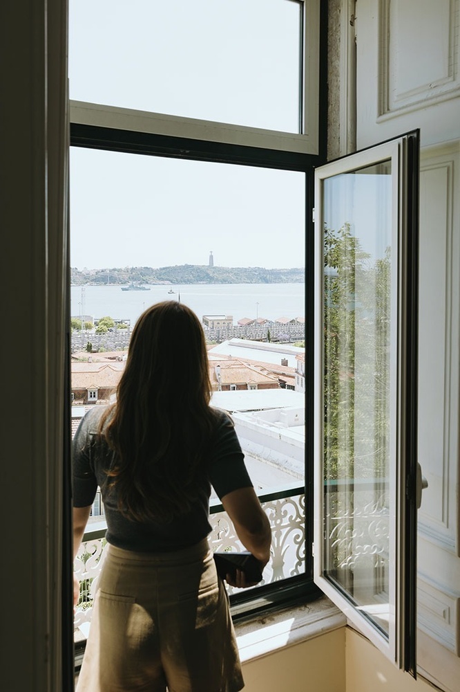 uma mulher está olhando para fora de uma janela aberta