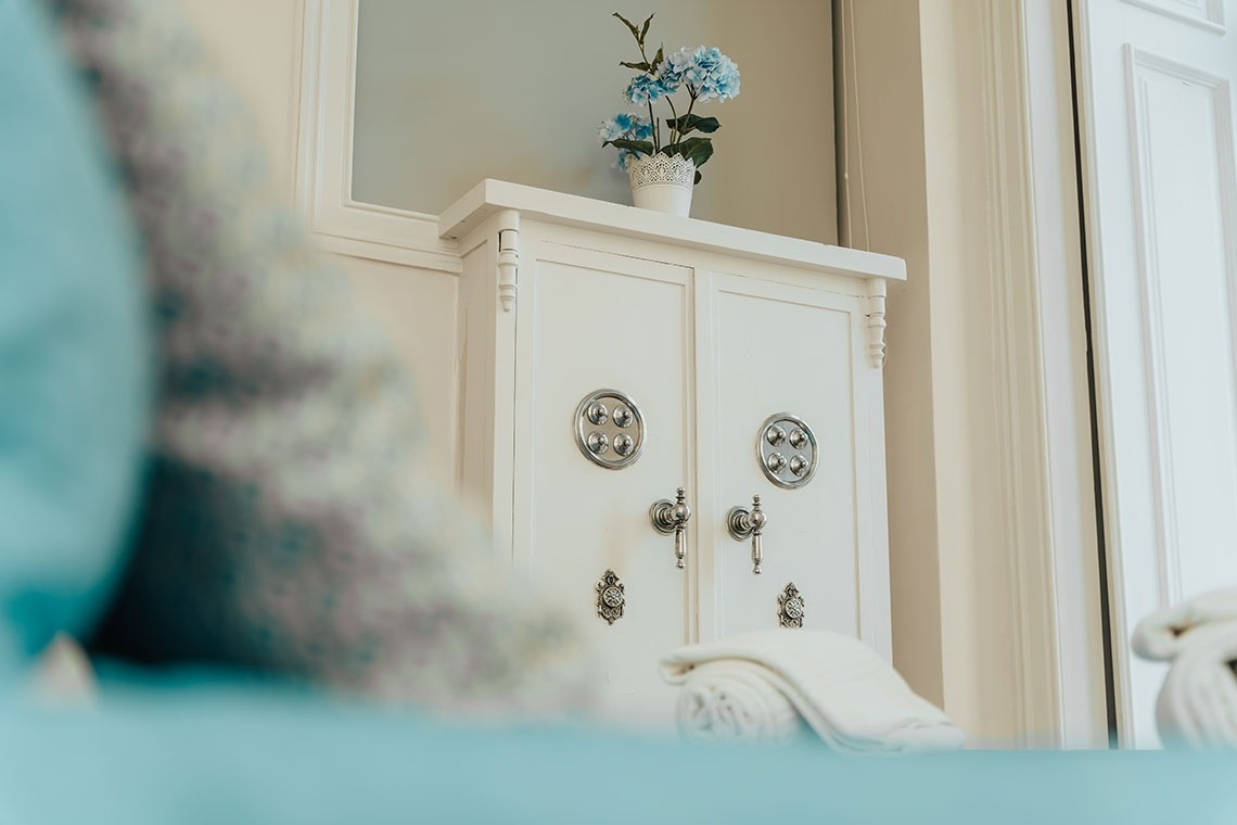 a vase of flowers sits on top of a white cabinet