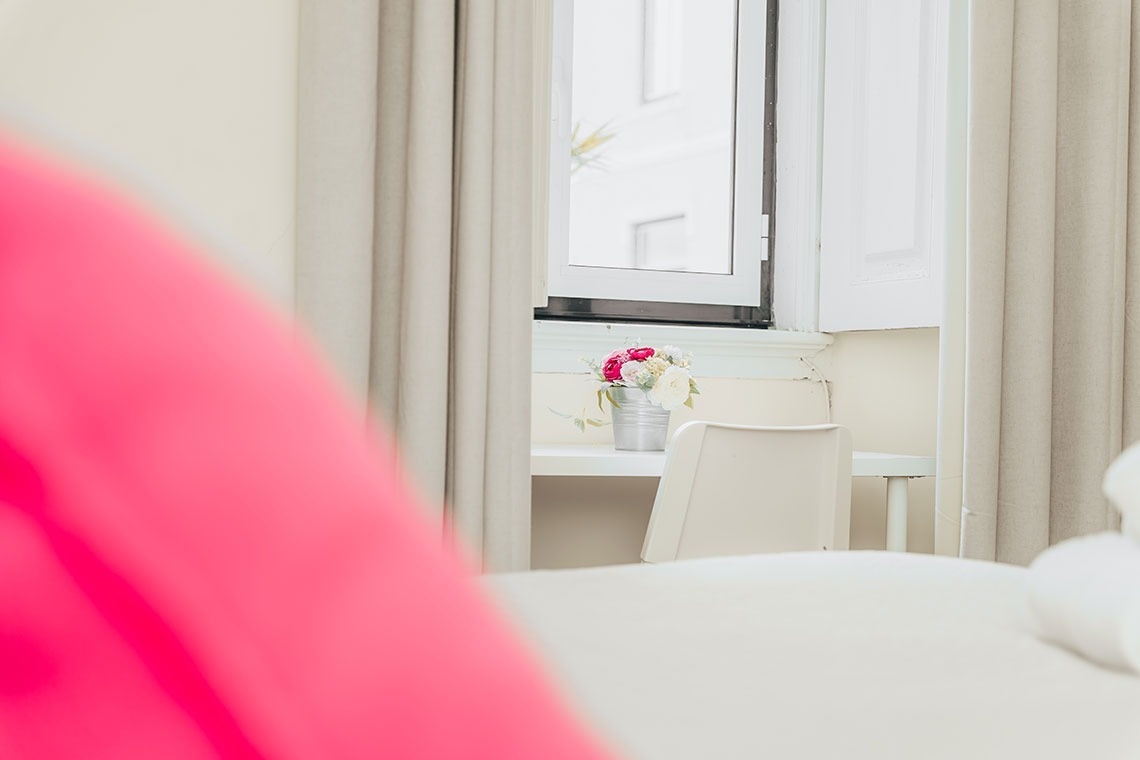 a white desk with a vase of flowers on it
