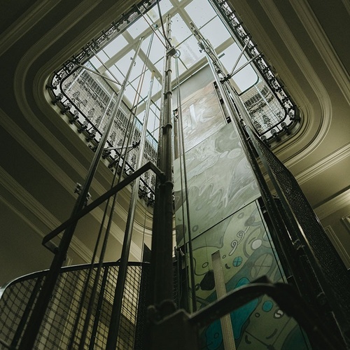 looking up at the ceiling of an elevator with a stained glass window