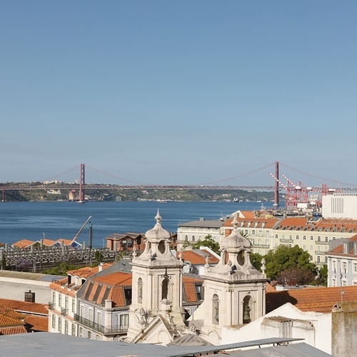 an aerial view of a city with a bridge in the background