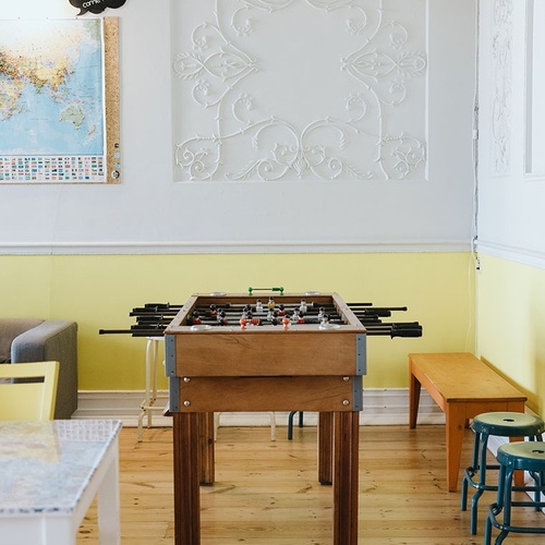 a room with a foosball table and a sign that says show us your travel stories
