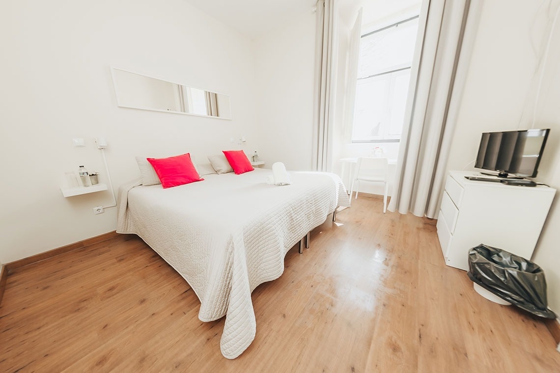a bedroom with a large bed and a flat screen tv