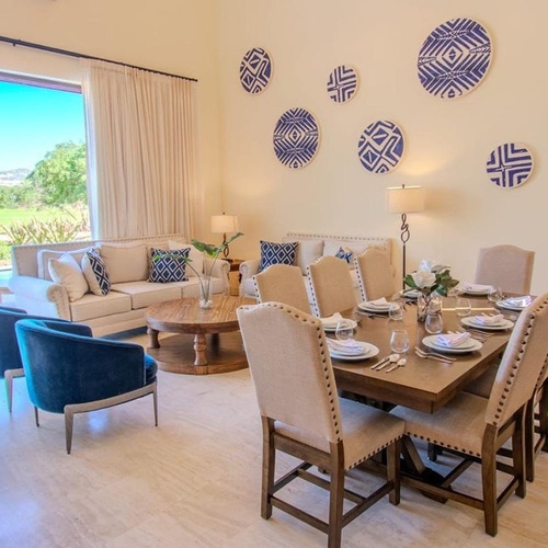 Salón-comedor diáfano con vista a un jardín y piscina.