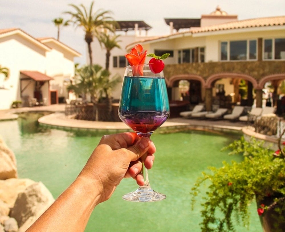 una mujer se relaja en una piscina con una cascada que cae sobre ella