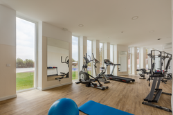 Gym at hotel with treadmills, elliptical, and weight machine. Luna Corporativa