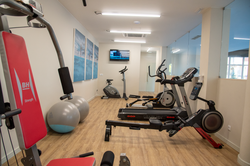 Gym with exercise equipment, including a treadmill and Luna Corporativa bike, perfect for guests.
