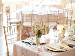 Elegante mesa de banquete Luna Corporativa con sillas doradas y centros de mesa florales.