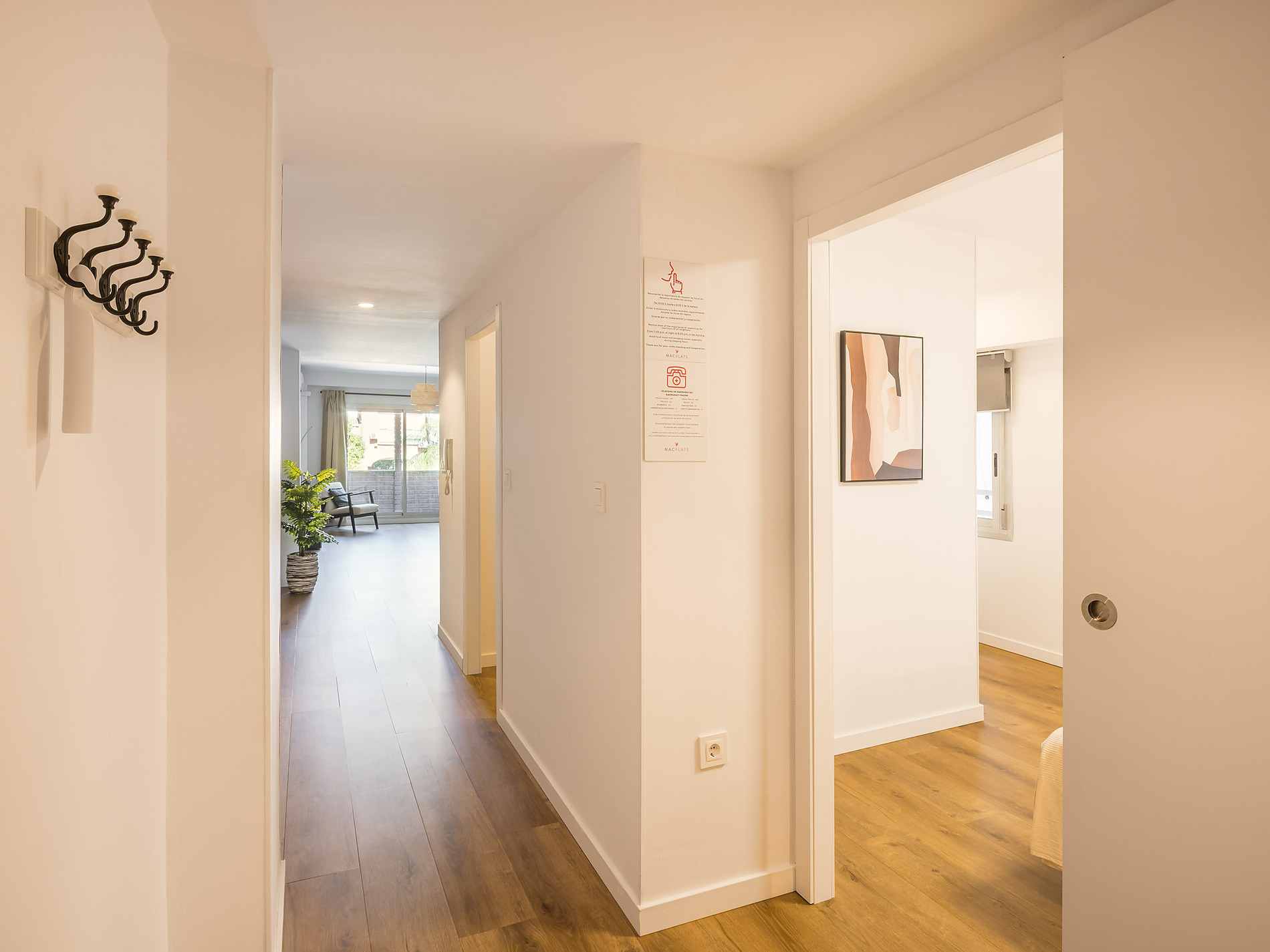 Modern hallway in a hotel with a coat rack, plant, and abstract art. Macflats: Ciudad de las ciencias