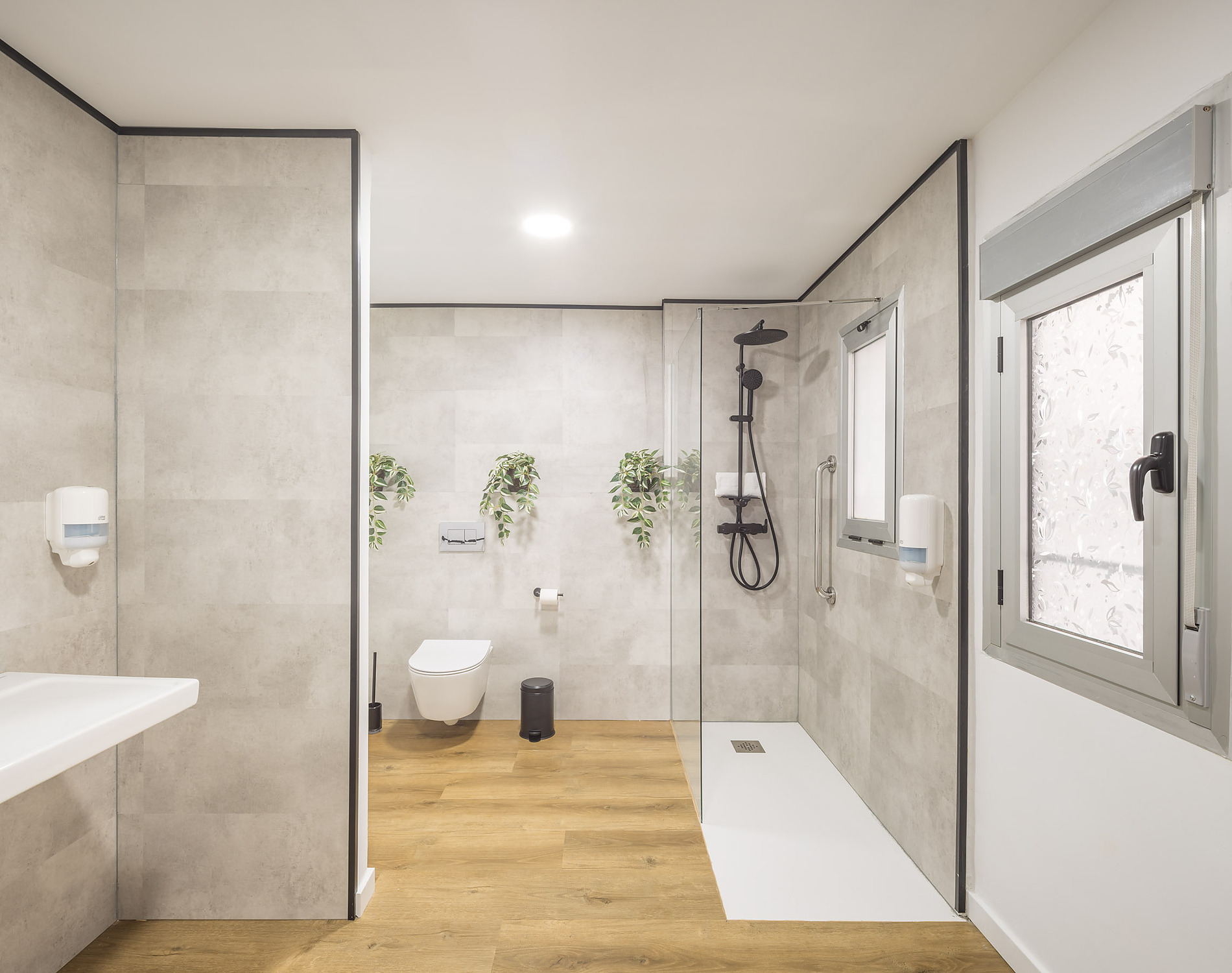 Modern accessible hotel bathroom with walk-in shower, toilet, and sink. Macflats: Ciudad de las ciencias