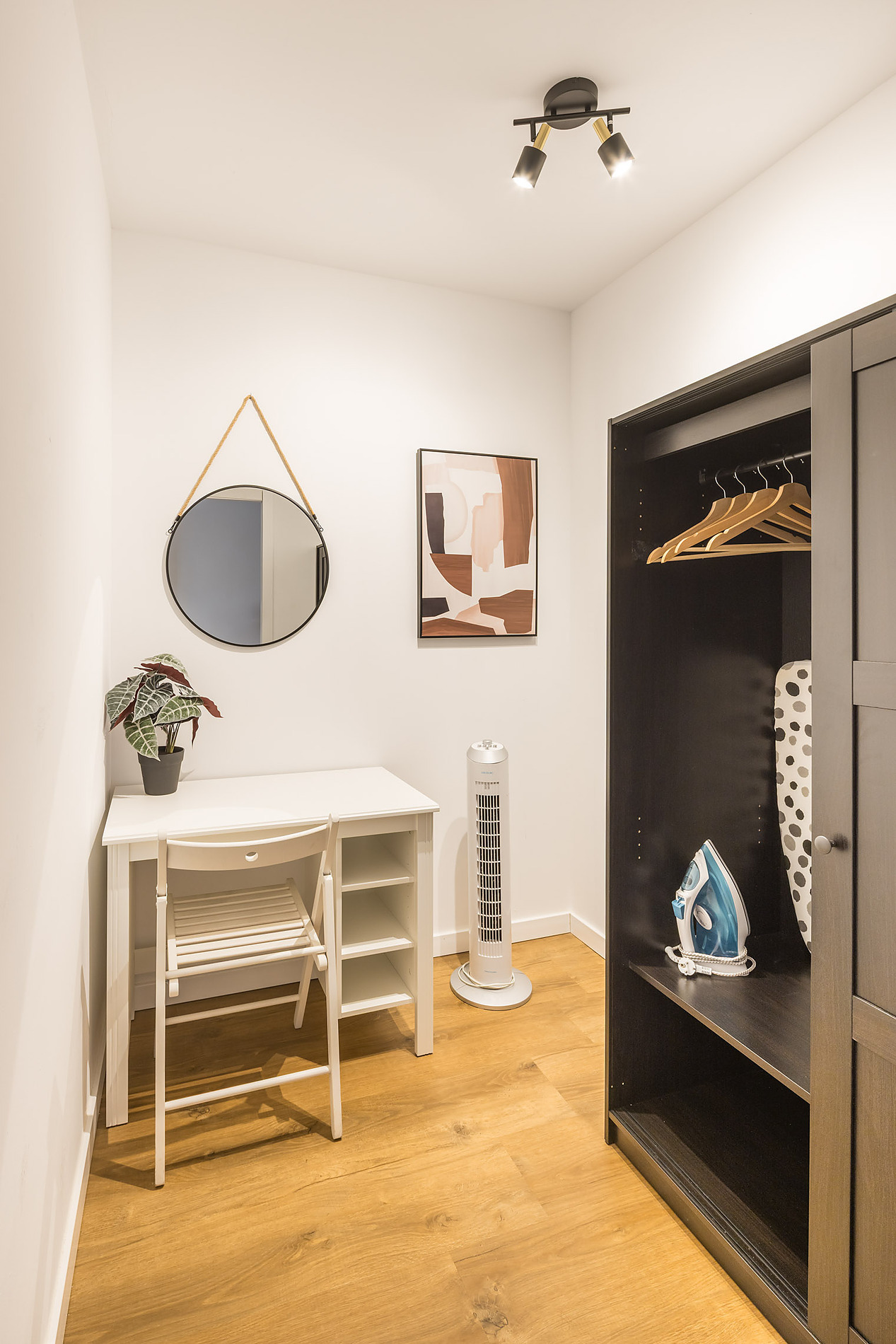 Desk and closet with ironing board and iron in a hotel room. Macflats: Ciudad de las ciencias