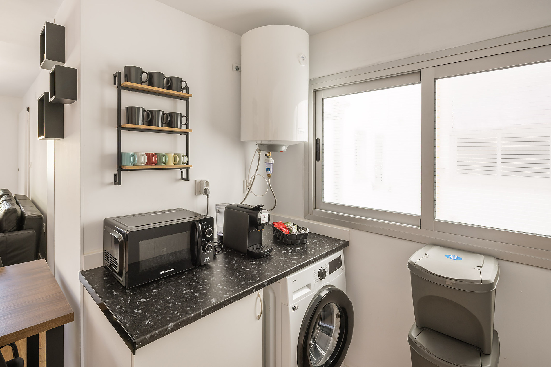 Modern kitchen with microwave, coffee maker, and washing machine, ideal for Macflats: Ciudad de las ciencias stays.