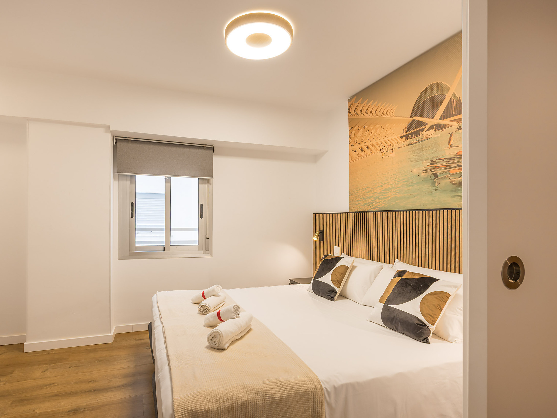 Modern hotel bedroom with king bed, large artwork, and a cozy atmosphere. Macflats: Ciudad de las ciencias