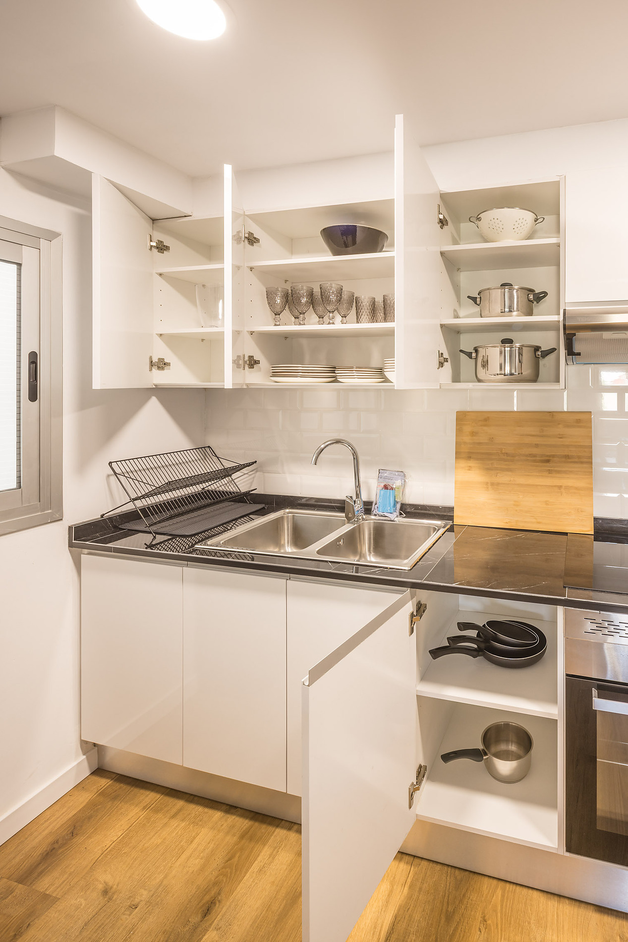 Modern Macflats: Ciudad de las ciencias kitchen with clean white cabinets, double sink, and ample storage space.