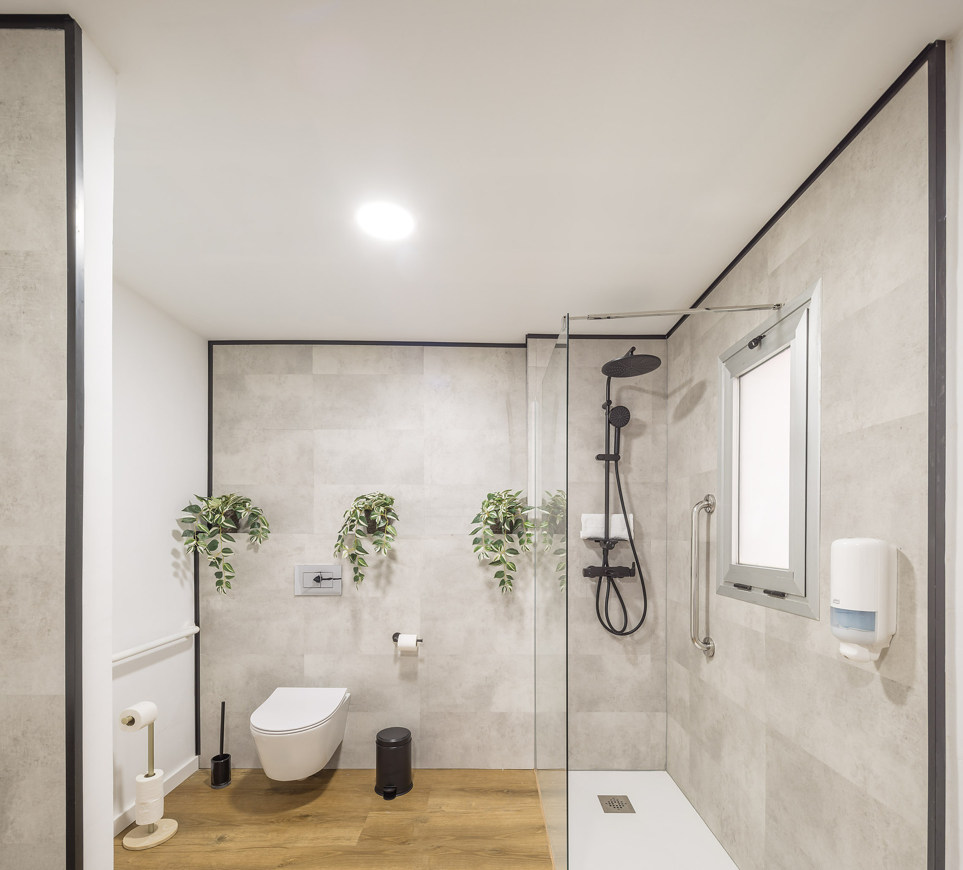 Modern hotel bathroom with shower, toilet, and plants. Macflats: Ciudad de las ciencias.