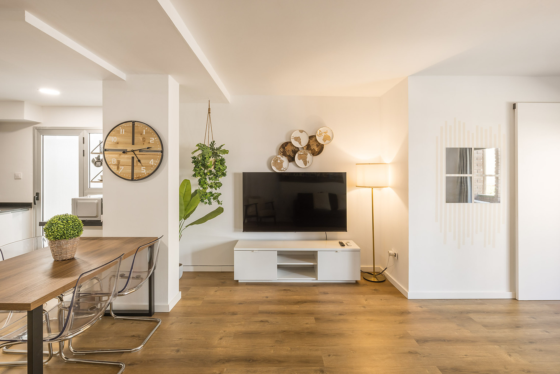 Modern dining and living area with Macflats: Ciudad de las ciencias, sleek TV, and plant decor.