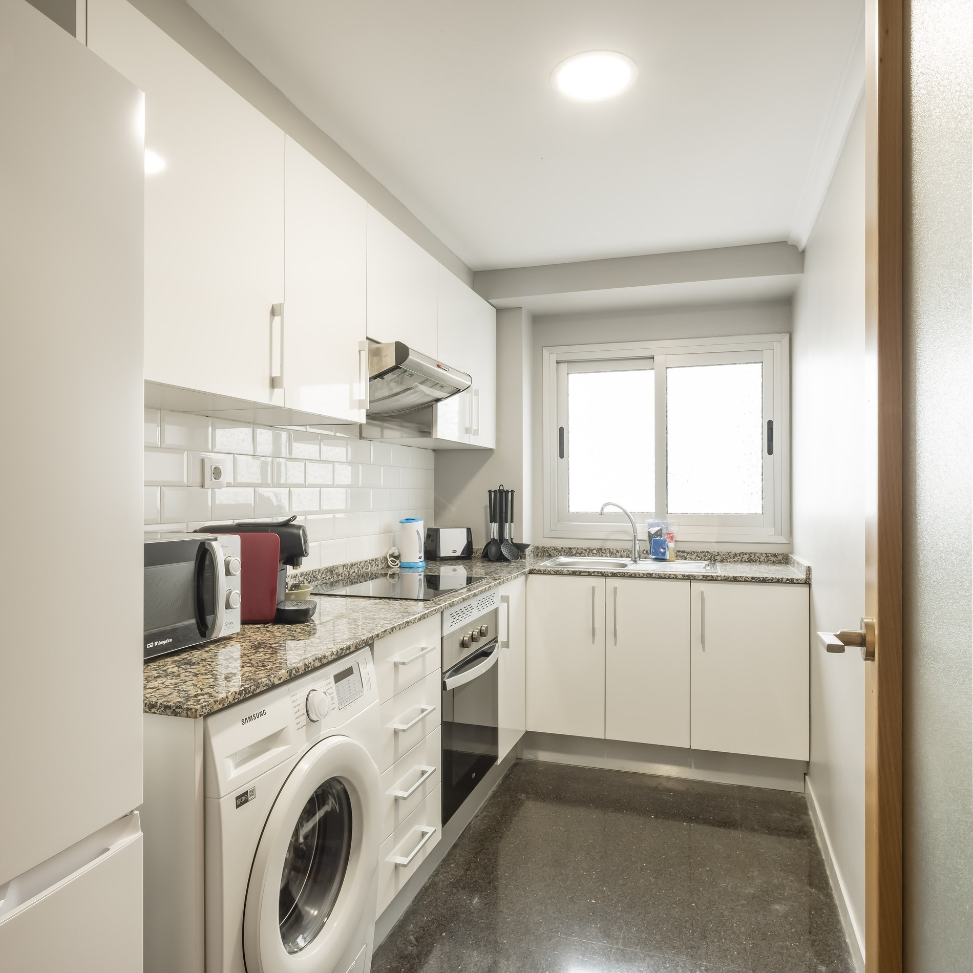 Modern white kitchen at Macflats Valencia, perfect for your stay.