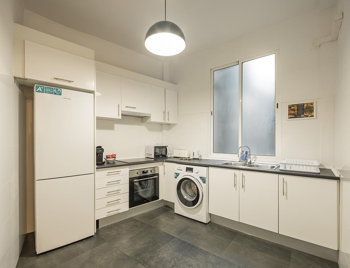 Cocina moderna con electrodomésticos blancos y ventana: Macflats Ayuntamiento | Macflats Valencia