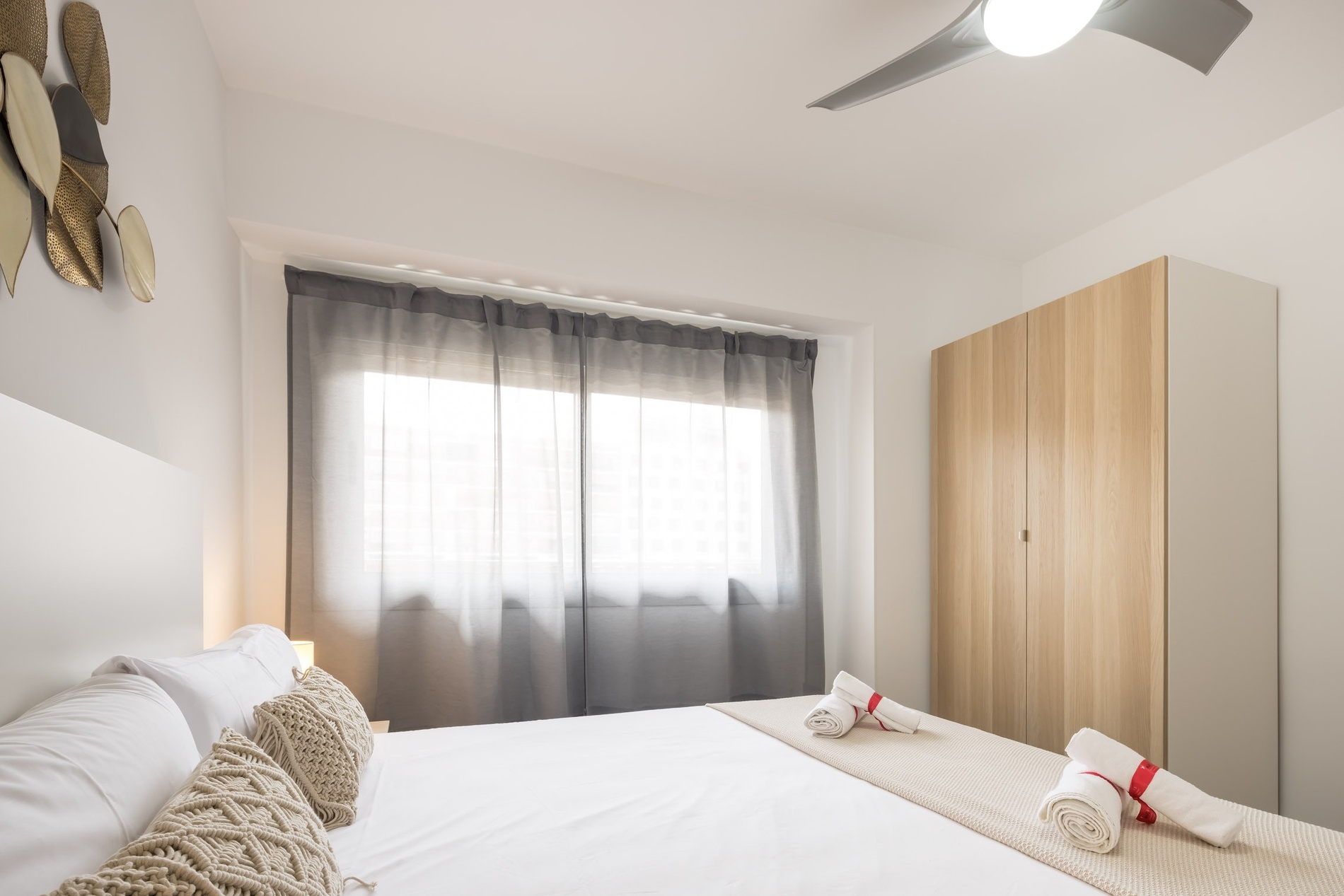 Modern bedroom with macrame pillows. Macflats Valencia Official Website.