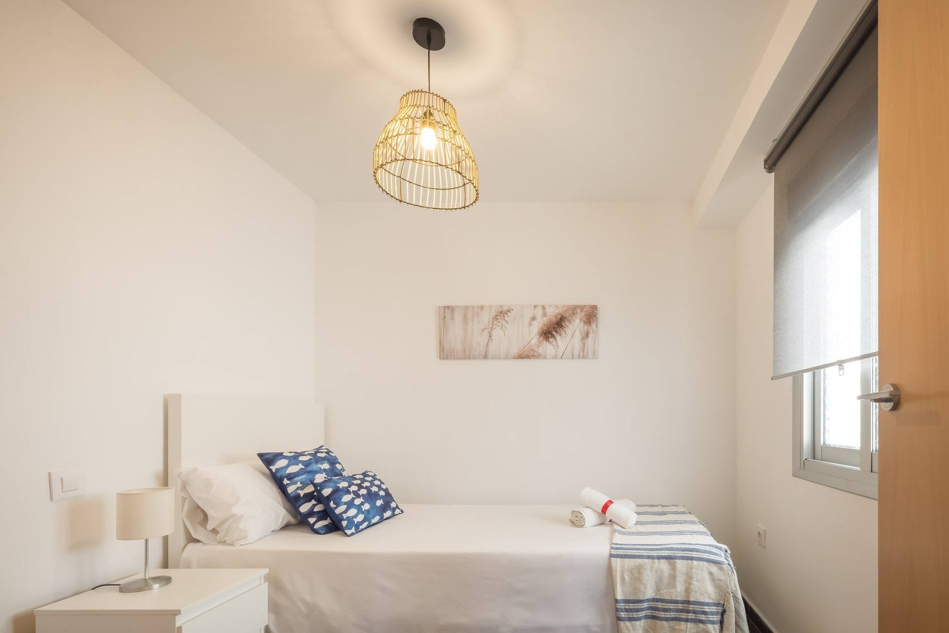 Modern bedroom at Macflats Ciudad de las Ciencias with twin bed and decorative pillows.