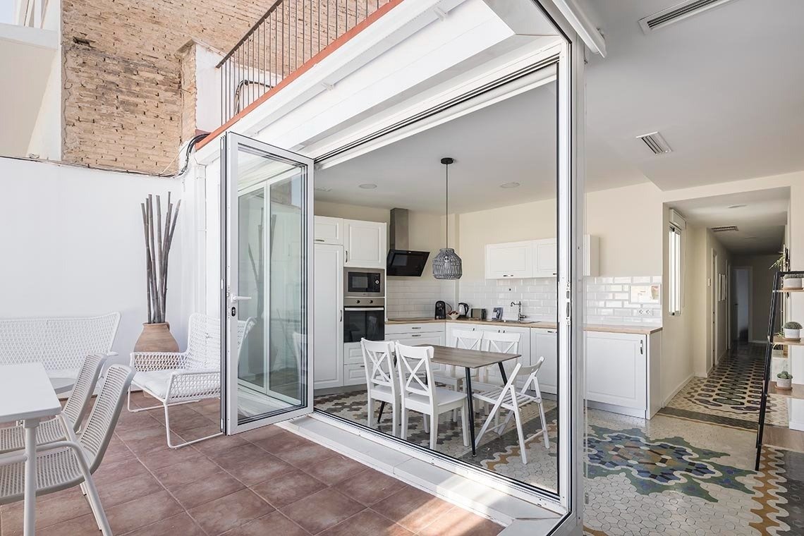 Terraza con asientos y cocina moderna, ideal para tu estancia en Macflats Ayuntamiento | Valencia.