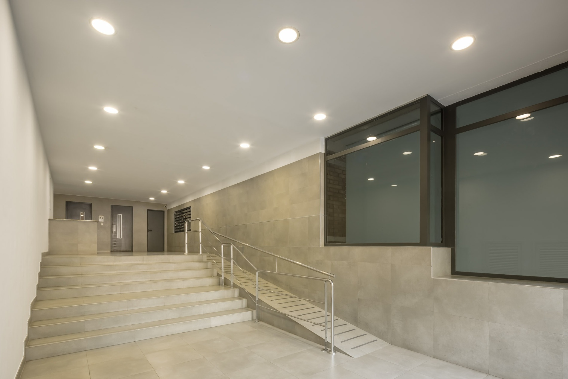 Modern apartment building lobby with stairs and ramp | Macflats Valencia Official Website
