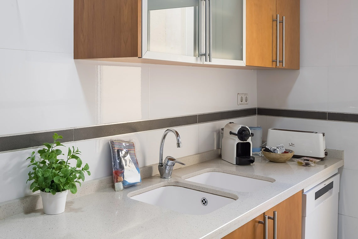Cocina moderna de Macflats Apartamento Puerto, con electrodomésticos y doble seno. Reserva oficial Macflats Valencia.
