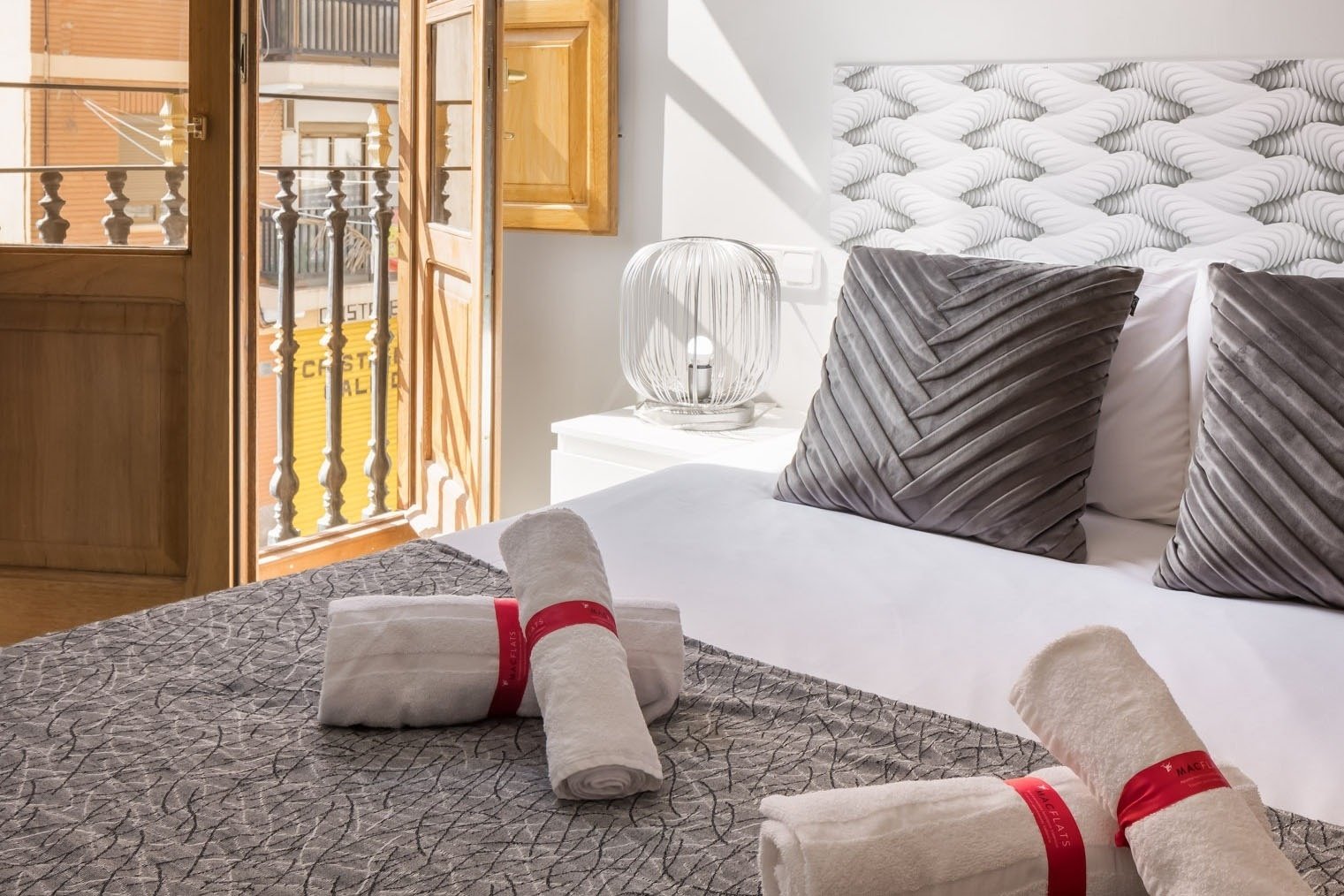 a bedroom with a balcony and a yellow sign that says ' alquiler ' on it